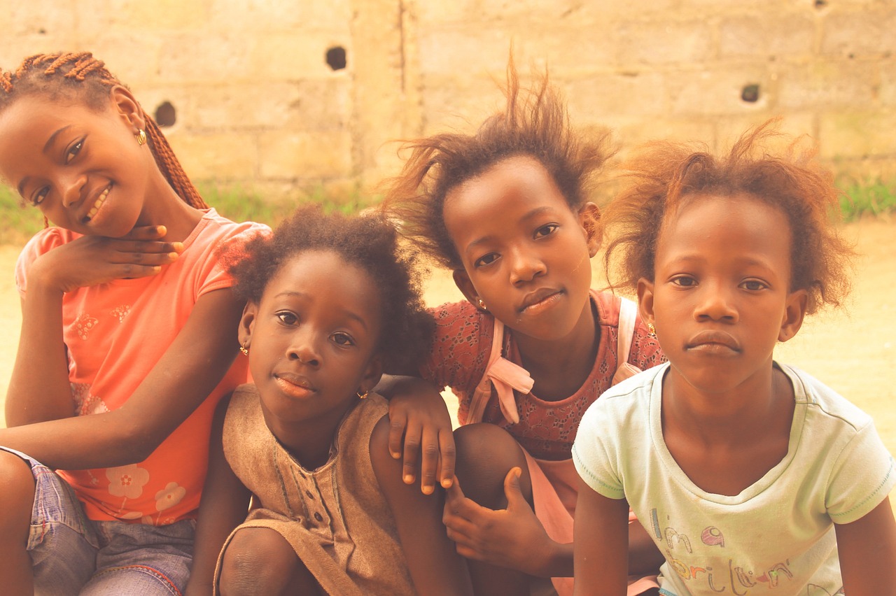Vier fröhliche Mädchen im Kongo, Darstellung der positiven Wirkung des Projekts "Schule Kongo" von Help 4 Life Global e.V.